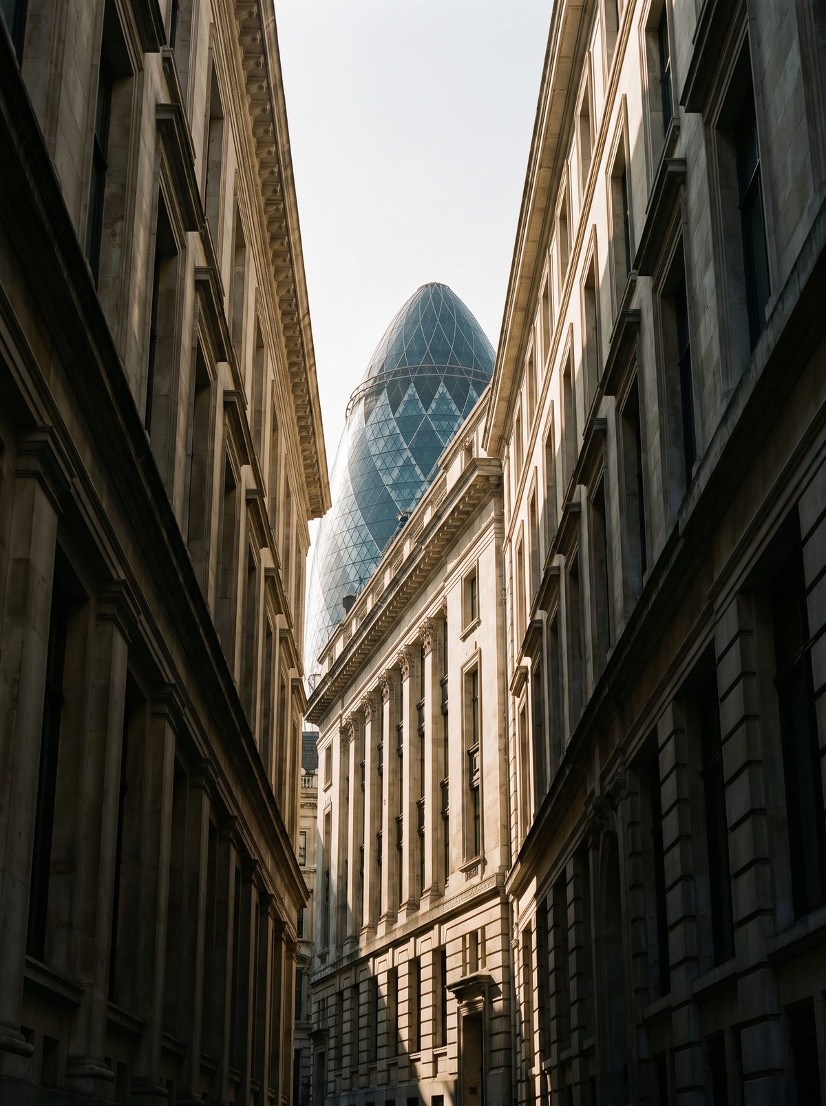 City of London street, the Gherkin rising between stone facades